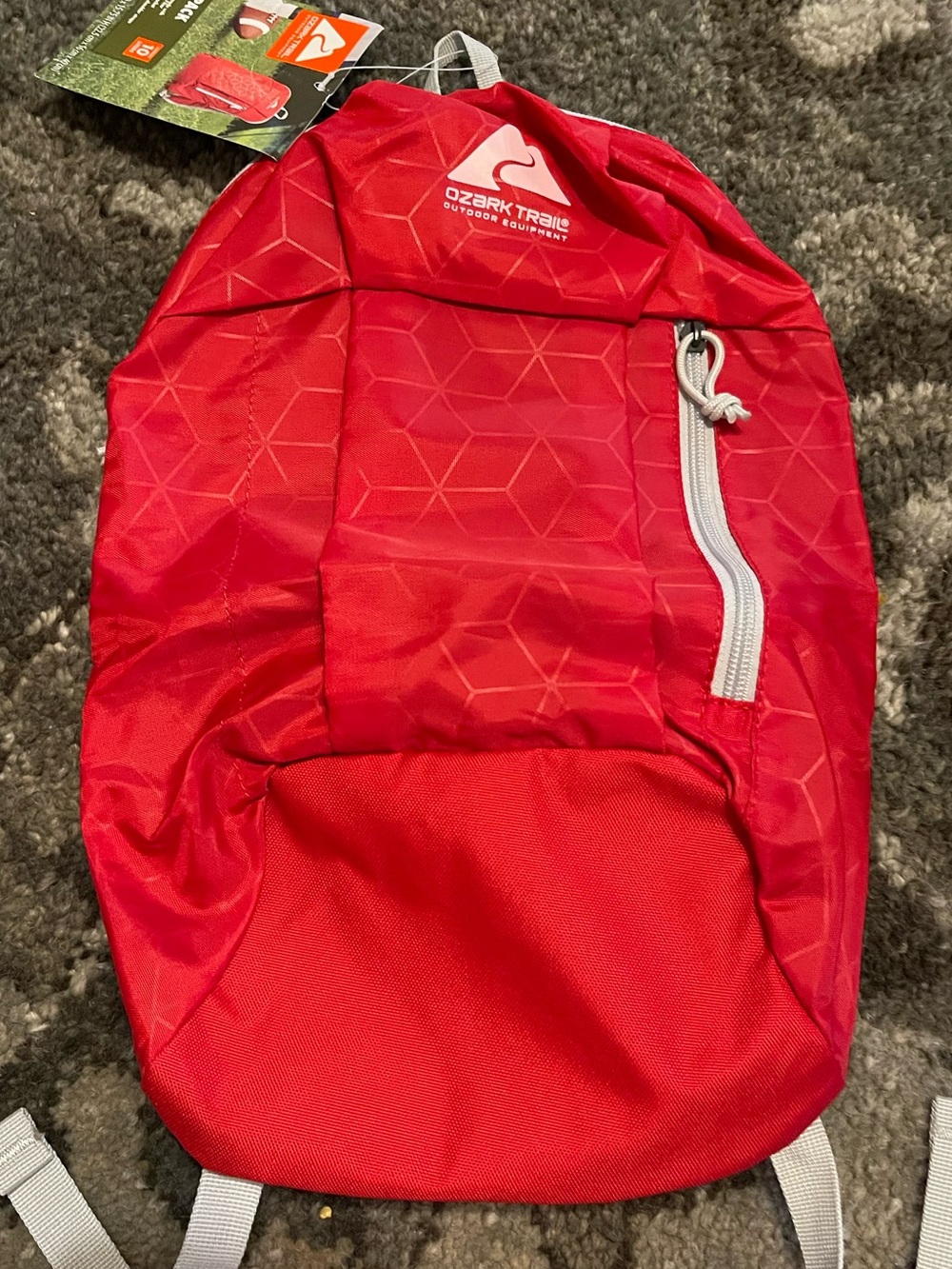 Ozark Trail brand 10-liter red daypack designed for lightweight hiking, camping